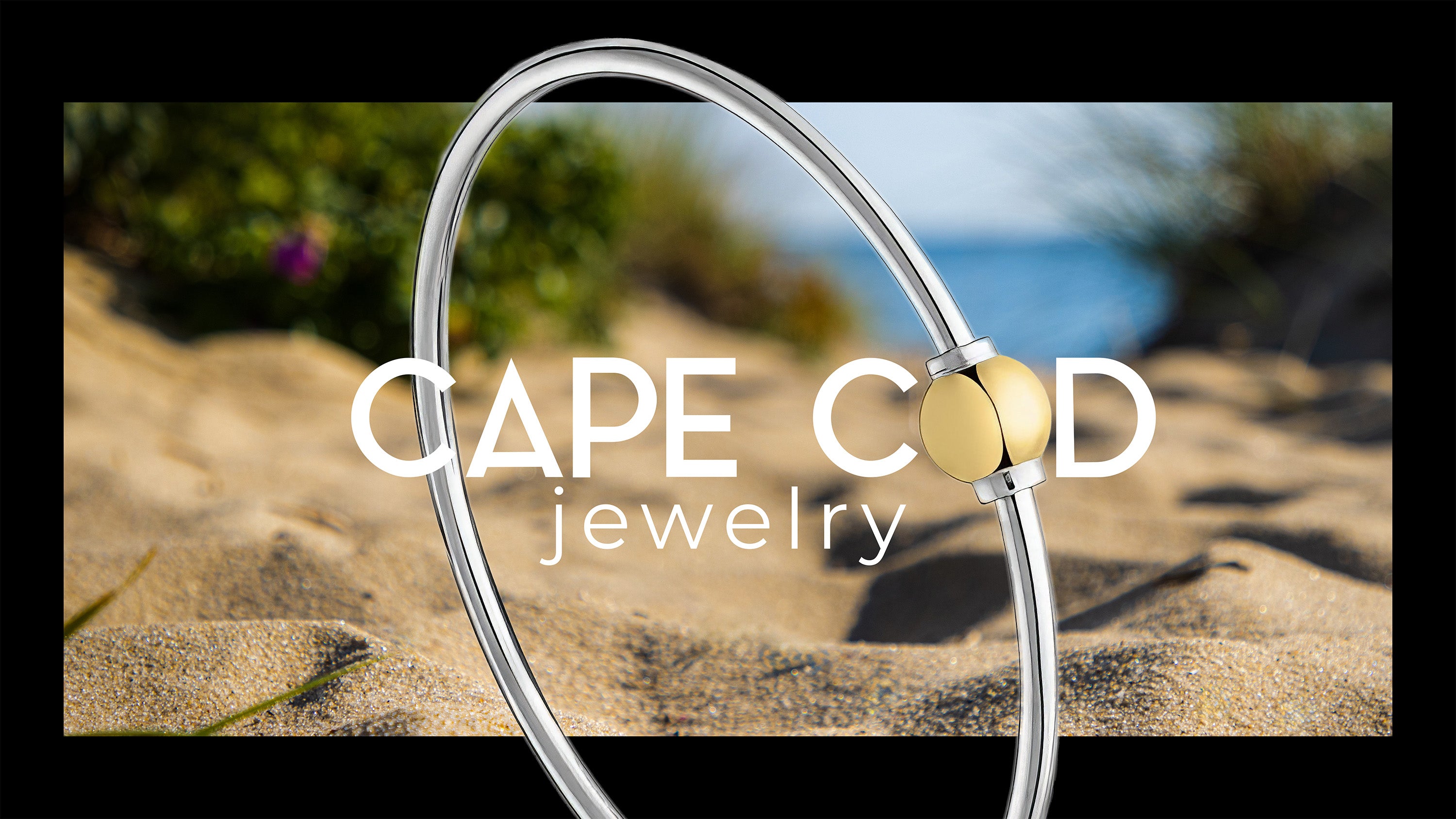 Cape Cod jewelry bracelet with gold accent displayed on sandy beach background