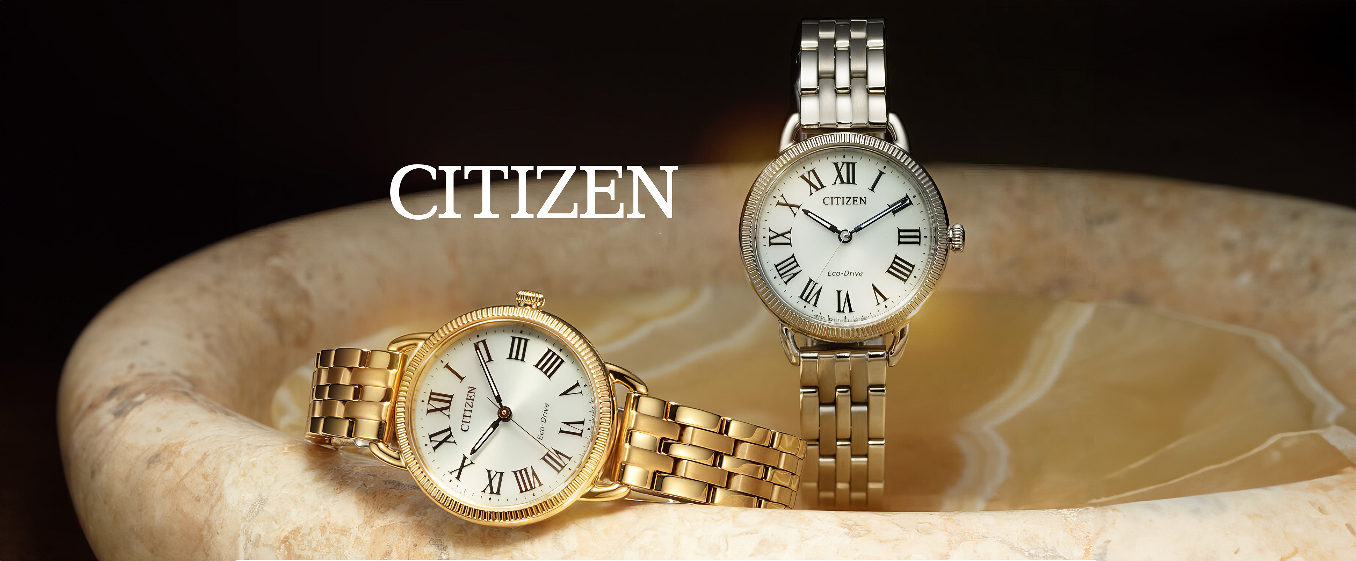 Citizen Eco-Drive gold and silver watches with Roman numerals on marble background