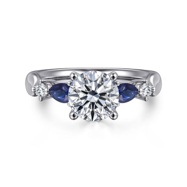 White gold engagement ring with round center diamond, blue sapphires, and side diamonds