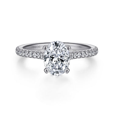 Oval cut diamond engagement ring with pavé band in white gold on white background