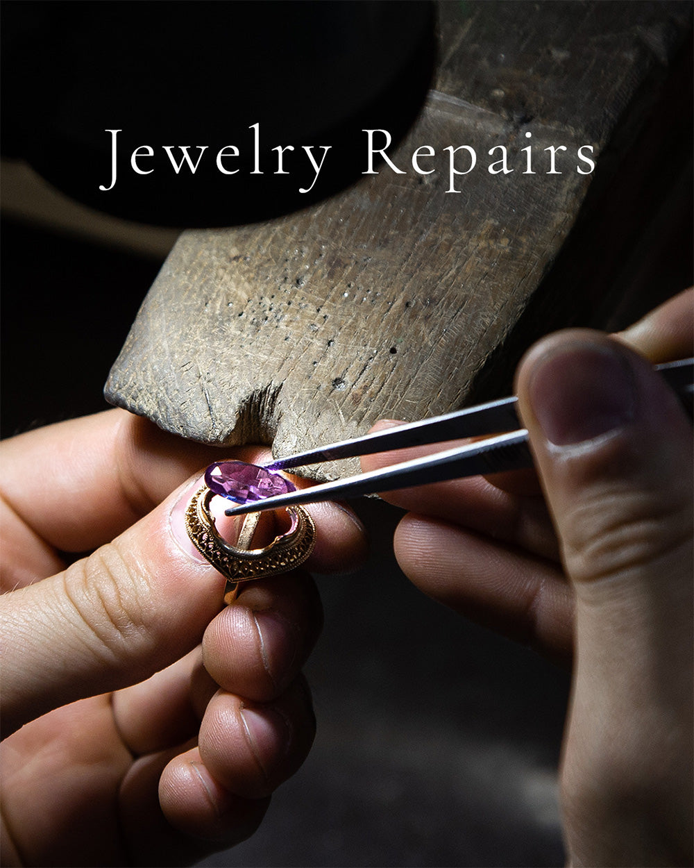 Closeup of hands doing gemstone ring repair under magnifier, jewelry repair service