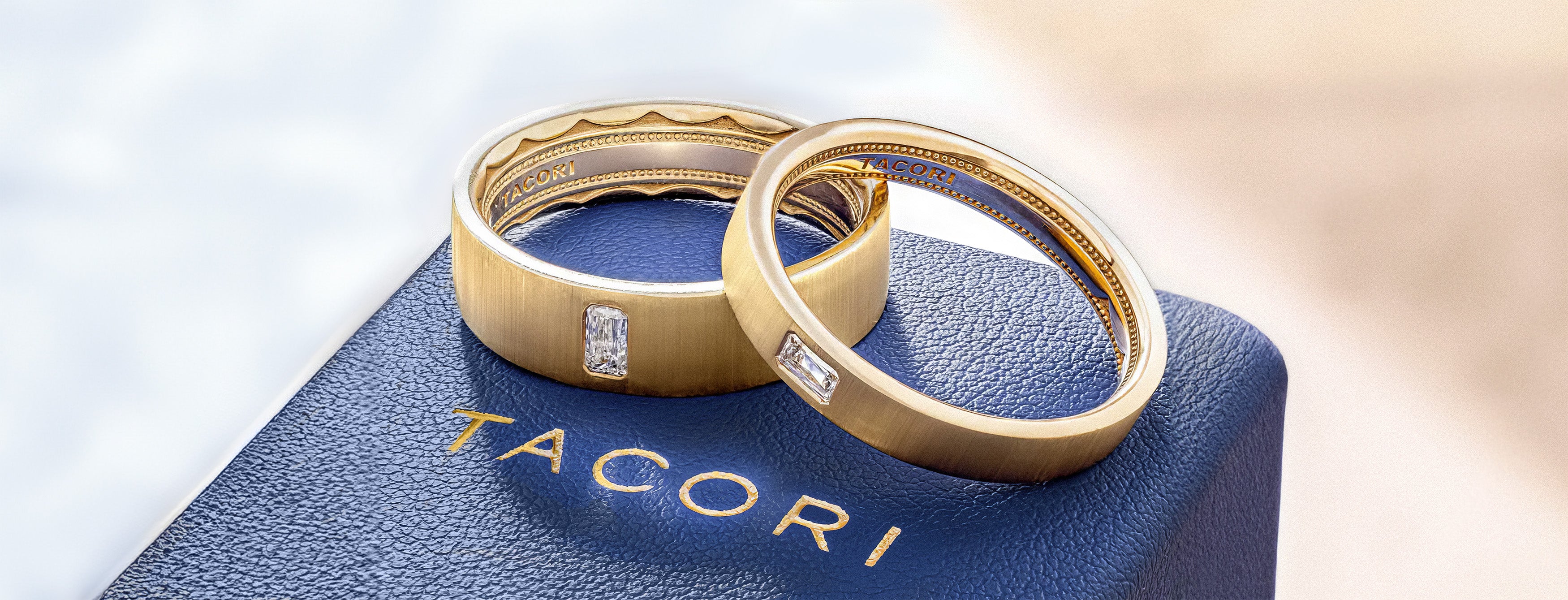 Gold diamond wedding bands on blue leather jewelry box