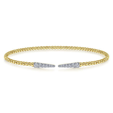 Open gold beaded bracelet with diamond-accented tapered ends on white background