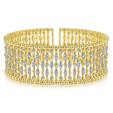 Wide gold cuff bracelet with intricate diamond accents in an openwork design