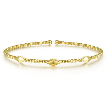 Gold beaded bangle bracelet with geometric accents on white background