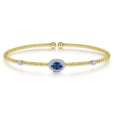 Gold beaded bracelet with blue oval gemstone center and diamond accents on white background
