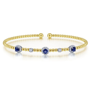 Gold beaded cuff bracelet with blue sapphires and round white gemstones accents