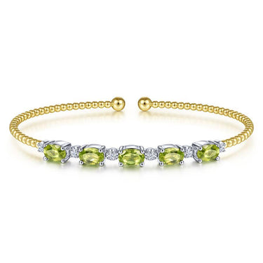 Yellow gold beaded cuff bracelet with oval green gemstones and white accent stones