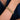 Gold textured bangle bracelet on woman's wrist, elegant jewelry against a navy dress