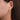 Gold and diamond twist stud earring worn on ear, elegant and modern jewelry style