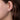 Leaf-shaped diamond stud earring in white gold worn on ear