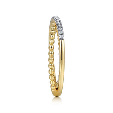 Gold beaded band ring with a row of small round diamonds on top, modern jewelry design