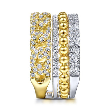 Stacked gold and silver rings with round and pavé set diamonds on white background