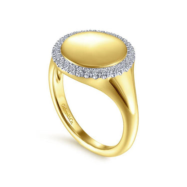Yellow gold ring with round polished top and diamond halo on white background