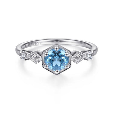 White gold ring with hexagonal blue gemstone and diamond accents