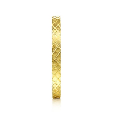 Yellow gold wedding band with diamond-cut lattice pattern on white background