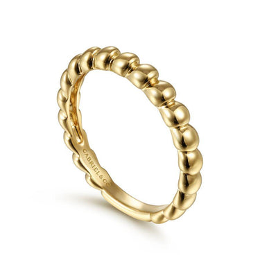 Beaded gold band ring with polished finish on white background