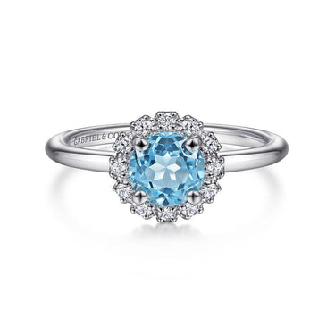 White gold ring with round blue topaz center stone and diamond halo