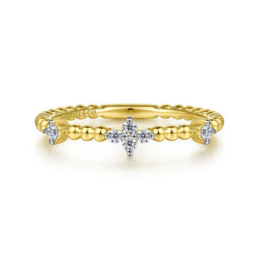 Yellow gold beaded band ring with diamond cluster accents on white background