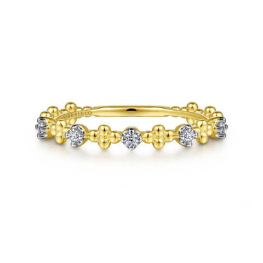 Yellow gold beaded diamond band ring with white gold accents on white background