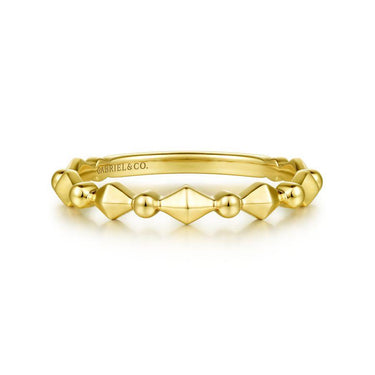 Geometric yellow gold stacking ring with textured bead and pyramid details on white background