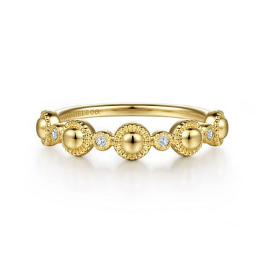 Yellow gold beaded band ring with round diamonds in bezel settings on white background