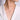 Woman wearing a delicate diamond cross pendant necklace with a white blouse