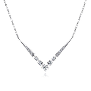 V-shaped white gold necklace with sparkling round diamonds on a plain background