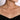 Woman wearing a delicate gold bar necklace with small diamonds on a bare neckline