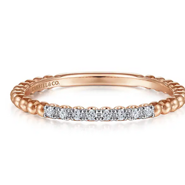 Rose gold beaded band ring with row of round diamonds on white background