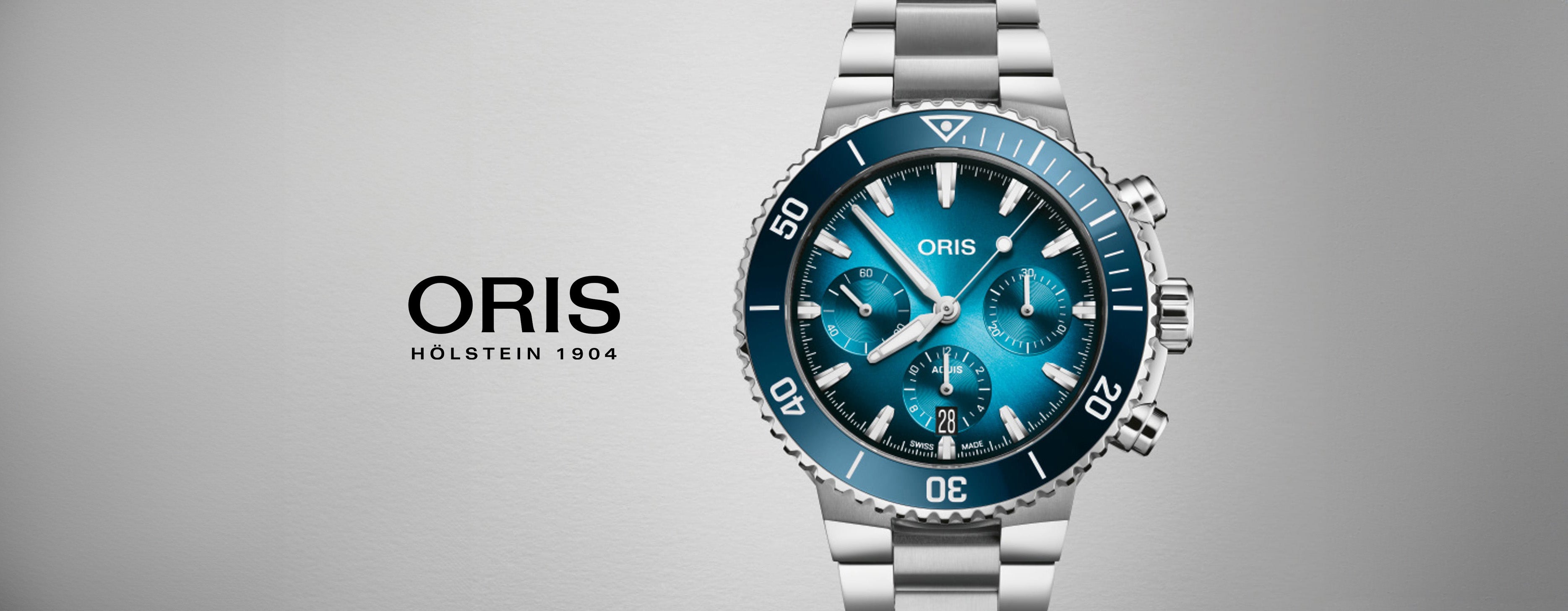 Luxury Oris stainless steel dive watch with blue dial and chronograph on grey background